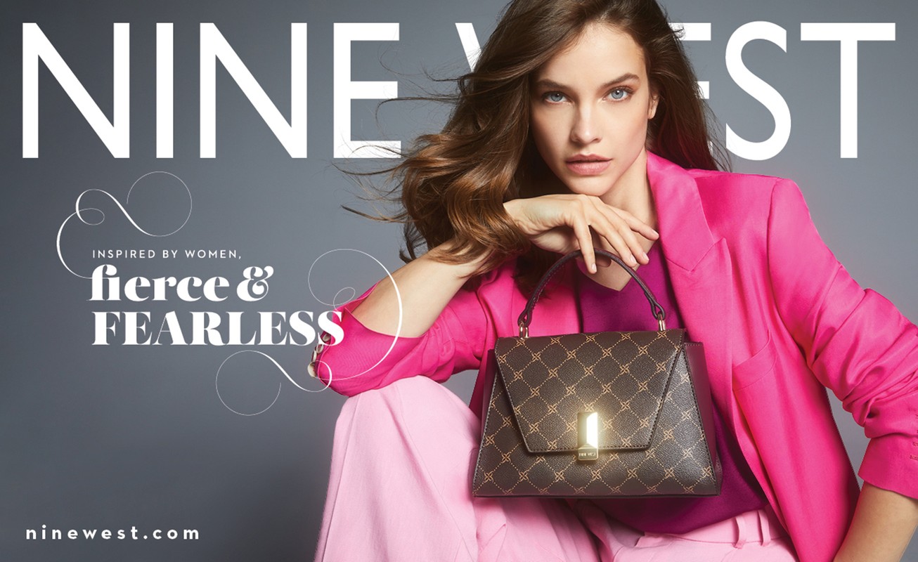 Nine West ad featuring a poised woman in a pink suit holding a structured brown purse with a geometric pattern against a gray backdrop.