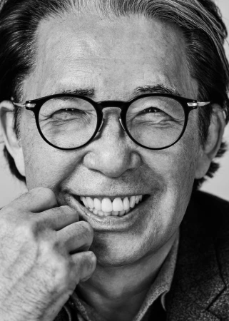 Close-up black and white portrait of an older man wearing round eyeglasses and smiling broadly