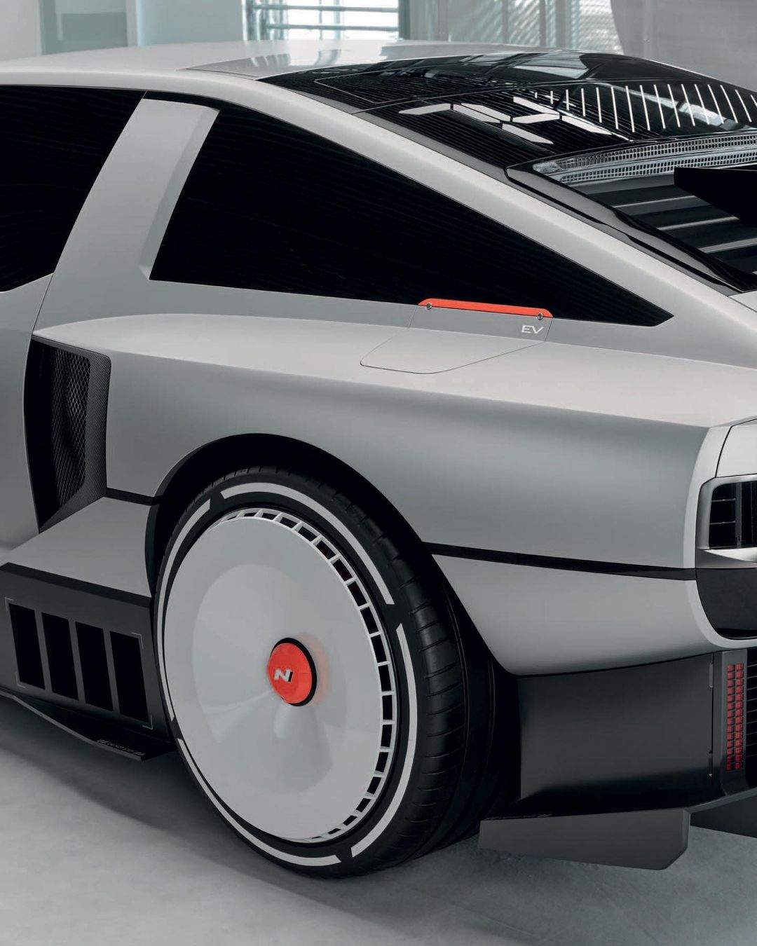Silver Hyundai N Vision 74 concept car showcases its unique silhouette, aerodynamic wheels, and retro-futuristic design elements in detail.
