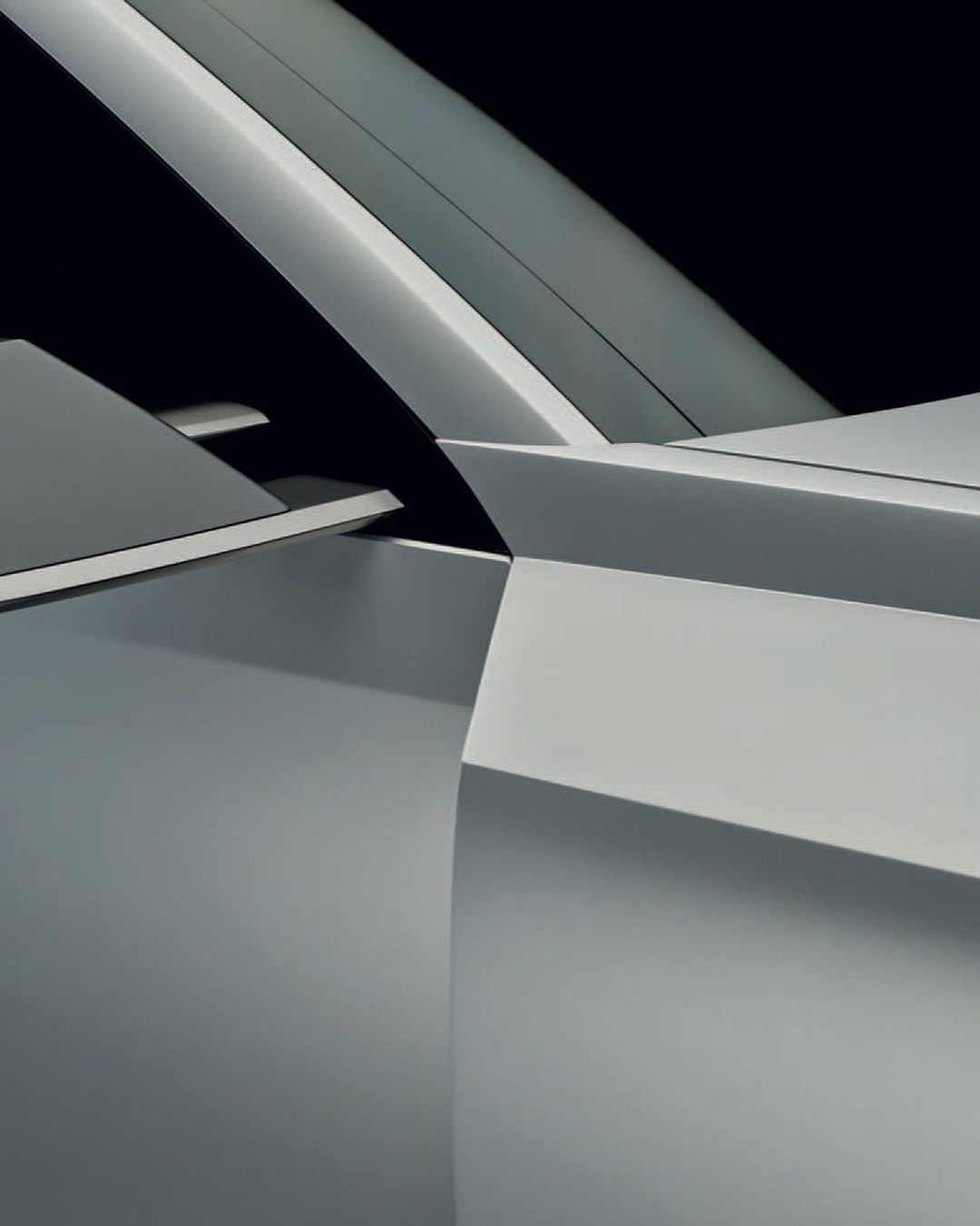 Silver automotive design showcasing angular lines and a futuristic aesthetic against a dark background, highlighting modern vehicle architecture.