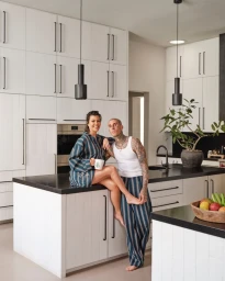 Kourtney Kardashian and Travis Barker in a modern white kitchen, photographed by Christopher Sturman