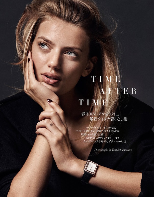 Close-up of a blonde woman with a watch, posing with her hand near her face in a studio with diffused lighting and gray background.