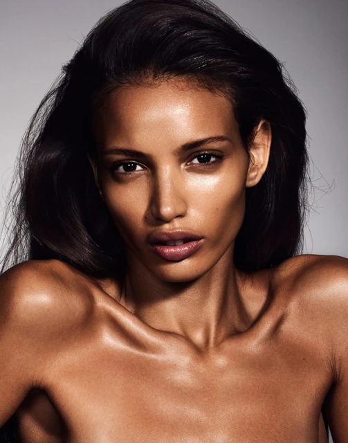 Close-up portrait of a woman with long black hair and tan skin in a beauty style, posing in a photo studio with neutral background.