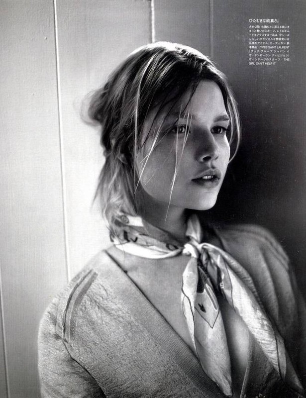 Black and white portrait of a young woman with a patterned scarf, soft light, and textured background. Fashion editorial shot.