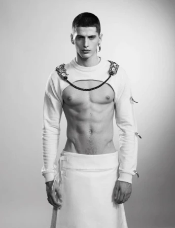 Portrait of a male model wearing a cut-out white top and skirt with hair styled by Colin Gold in Los Angeles.