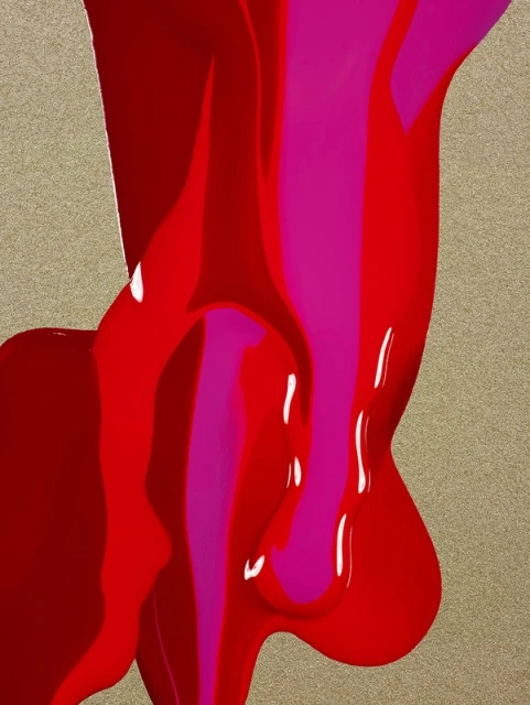 Abstract paint pouring down a beige surface, creating a dynamic and colorful visual with dominant red and pink hues.