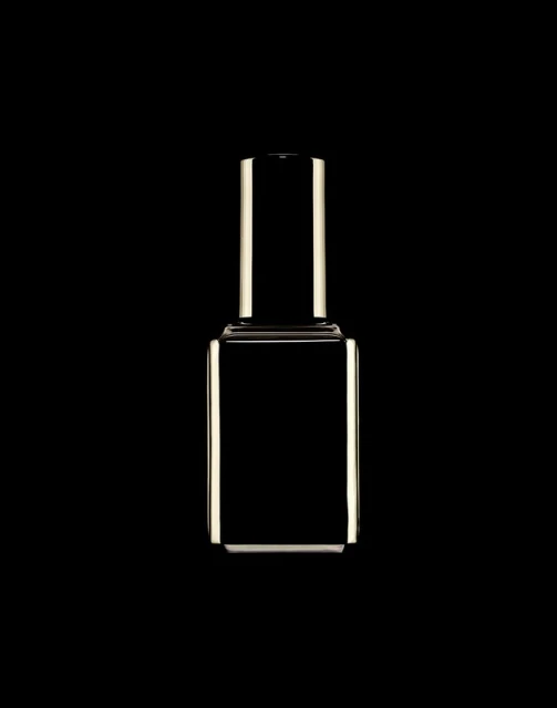 Isolated product shot of a reflective nail polish bottle with a rectangular body and cylinder neck against a solid black backdrop.