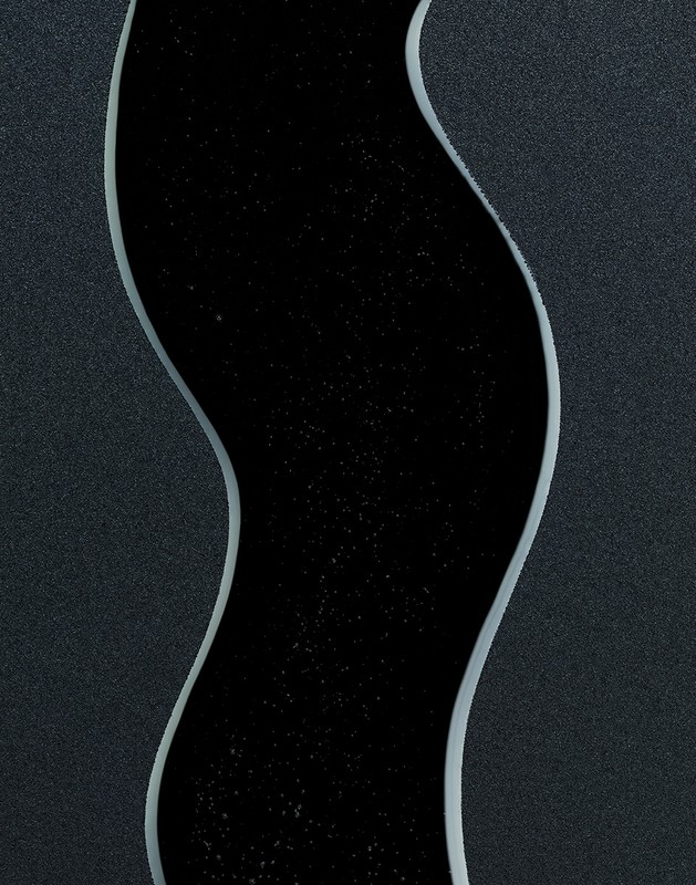 Abstract image of a black, river-like channel with subtle stars running vertically through a dark grey textured surface background.