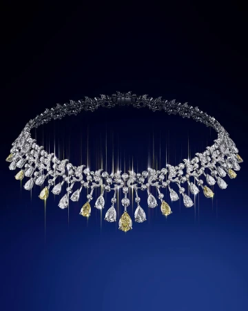 Elegant white gold necklace with yellow and white diamonds arranged in a floral pattern on a deep blue gradient background.
