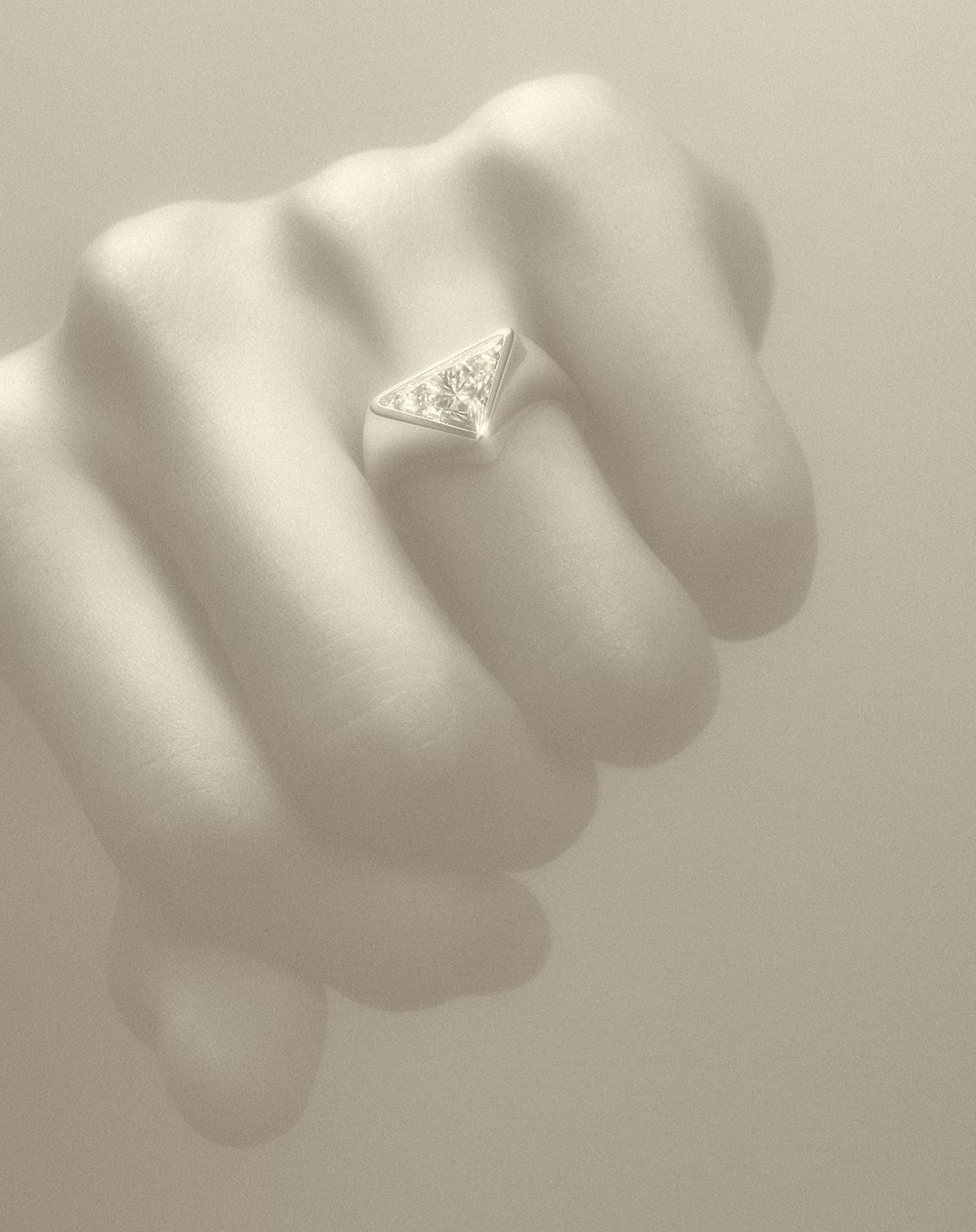 Close-up on a hand wearing a triangular ring. The ring is silver-colored, with a triangular design, and it's placed on the ring finger.