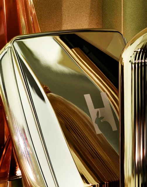 Close-up of Hourglass brand makeup compact with the brand logo and the metal case reflecting light, showcasing gold color and textures.