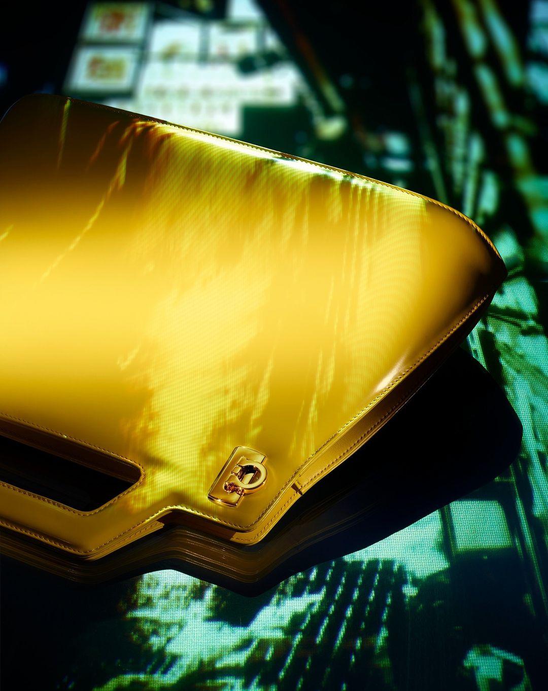 Shiny gold clutch bag with a dark shadow and blurred urban background, reflecting light with city buildings, creating a glamour shot.