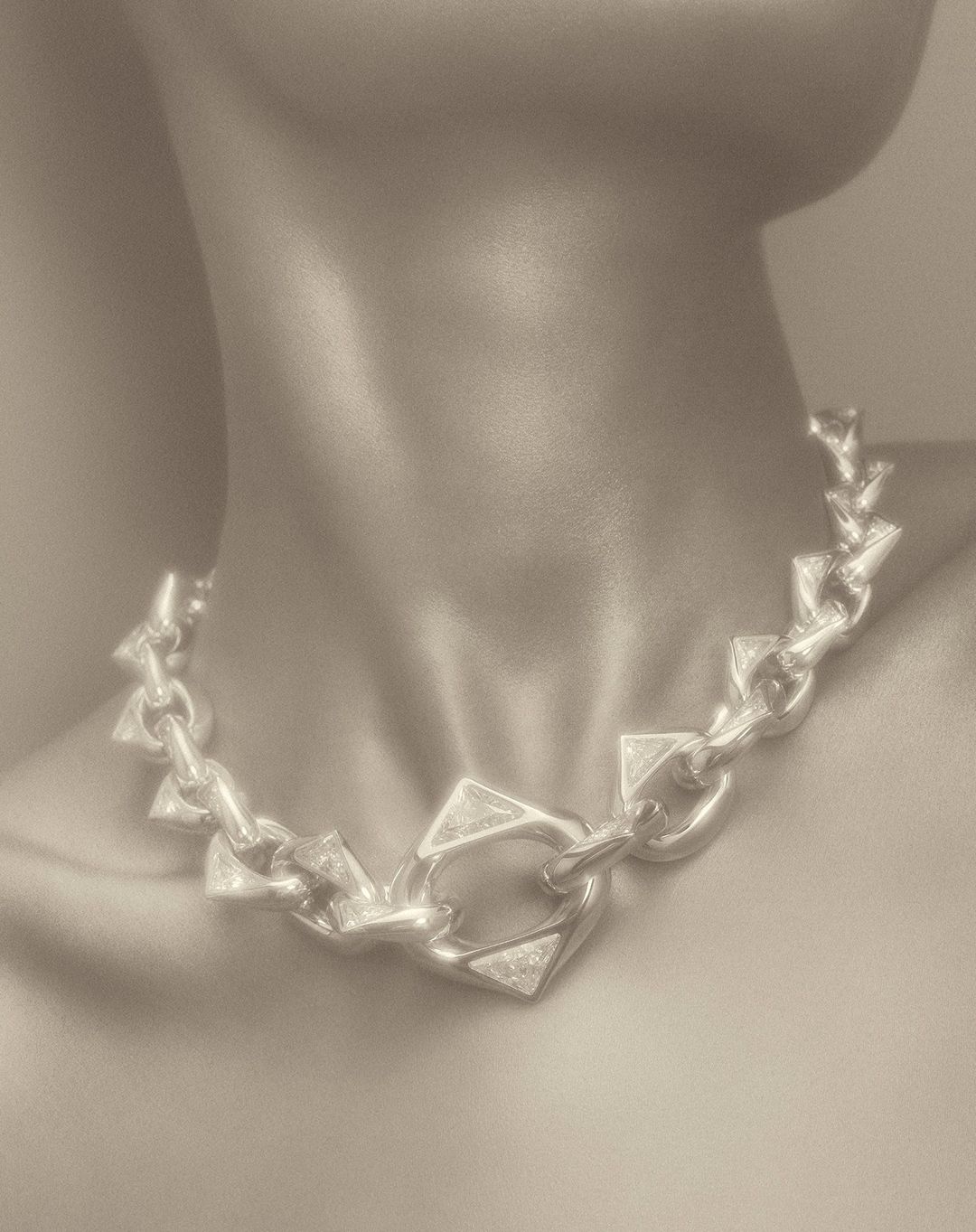 Close up portrait of a person wearing a chunky silver geometric chain necklace by photographer Coppi Barbieri