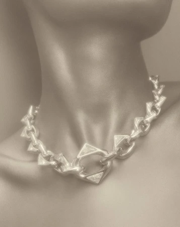 Close up portrait of a person wearing a chunky silver geometric chain necklace by photographer Coppi Barbieri