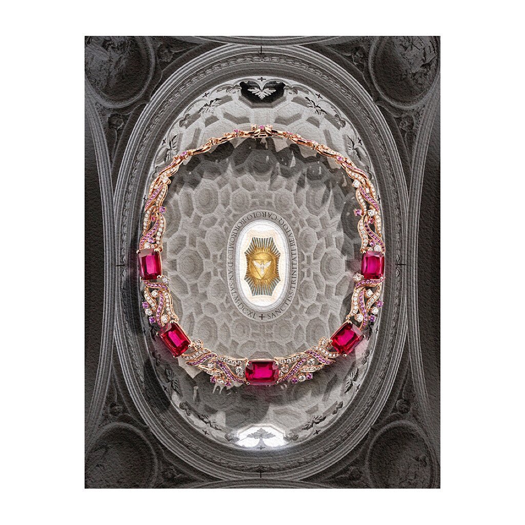 Elegant gold necklace with pink gemstones on a patterned ceiling backdrop, set against a white background for jewelry presentation.