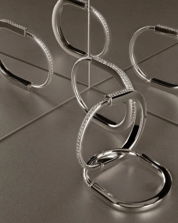 Elegant interlocking silver bracelets are arranged on a matching surface, creating a striking jewelry still life. Studio shot.