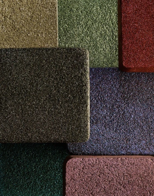Abstract close-up of multi-colored, textured, rectangular mats in red, green, blue, pink, brown and grey shades, for backgrounds and textures.