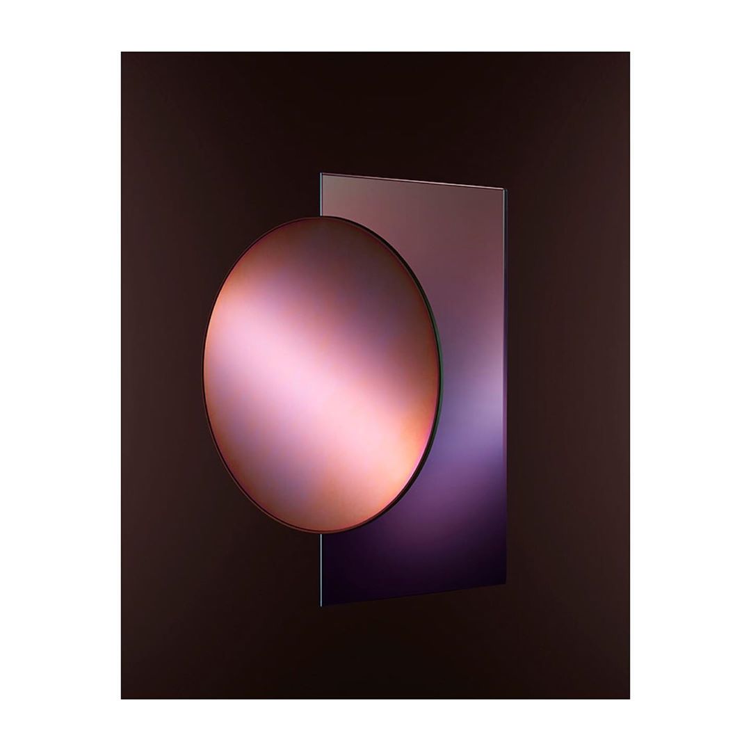Abstract image with a smooth, reflective, round surface intersecting a square, set against a dark, shadowy background.