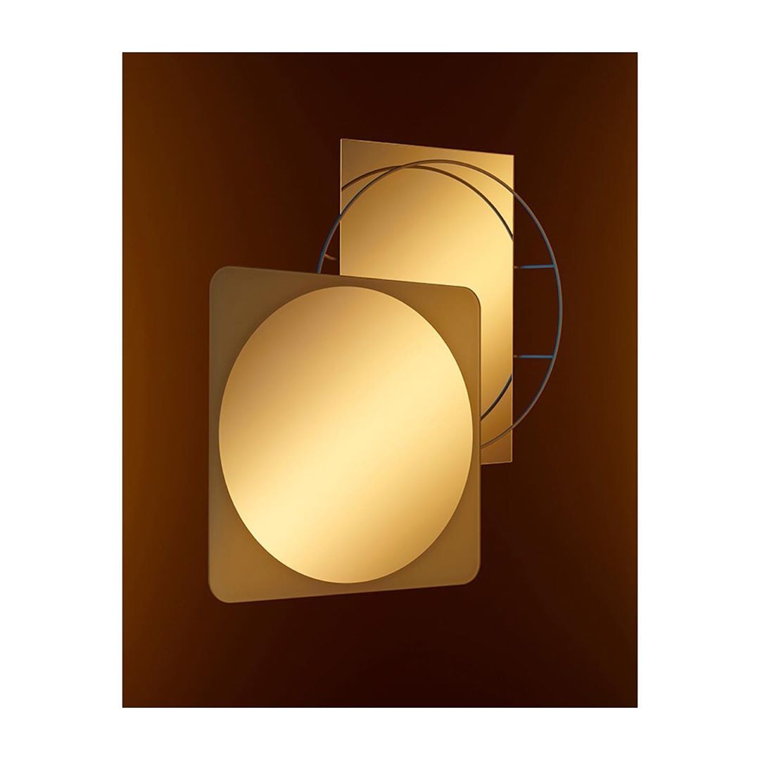 Abstract geometric art piece with gold square and circle shapes overlapping a metal circle grid on a textured brown background.