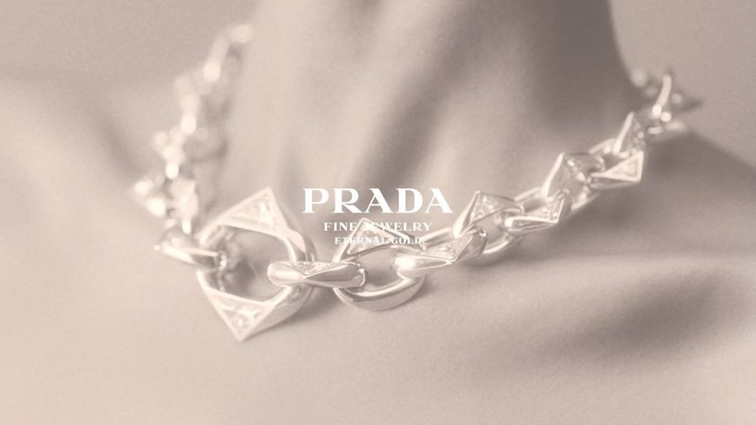 Close-up of a chunky silver chain necklace worn around the neck, featuring prominent geometric triangular links.