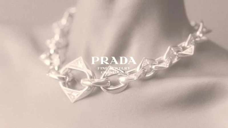 Close-up of a chunky silver chain necklace worn around the neck, featuring prominent geometric triangular links.