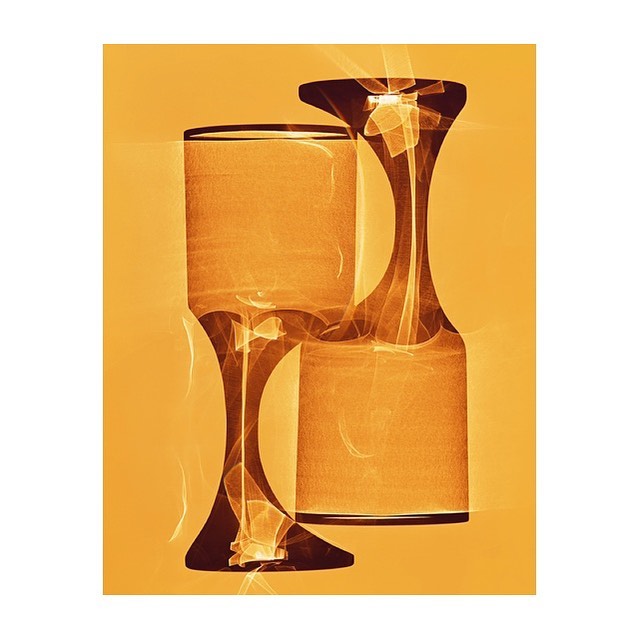 Abstract image of two glass objects in shades of orange and brown, set against a vibrant orange background, creating a surreal design.