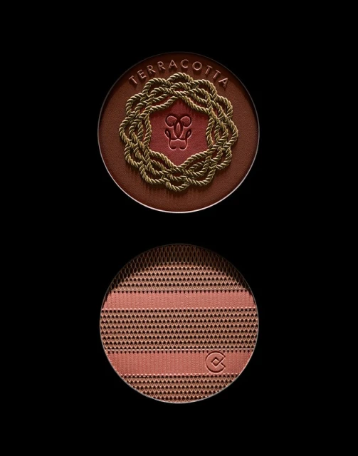 Close-up of terracotta bronzing powder compacts from Guerlain. The top features a rope wreath and the bottom has a geometric pattern.