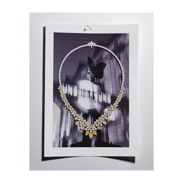 A black and white photograph of a diamond necklace, featuring a modern design and a butterfly motif in the background for luxury jewelry.