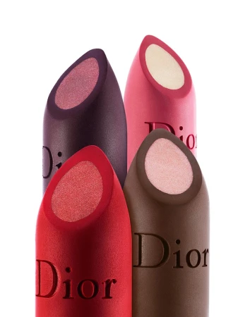 Close-up studio shot of four 'Dior' branded lipsticks in red, brown, pink, and purple shades against a bright white backdrop.