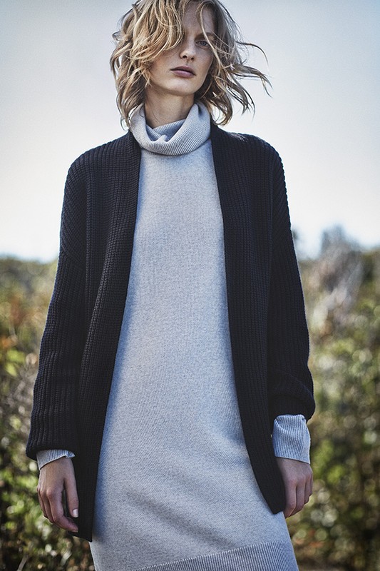 Model with tousled blonde hair wearing a grey turtleneck dress and black cardigan outdoors in Los Angeles