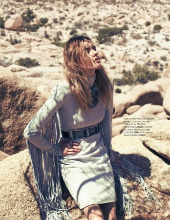 Woman in pale blue fringed dress with wide belt posing among desert rocks in Los Angeles by make-up artist Cynthia Sobek