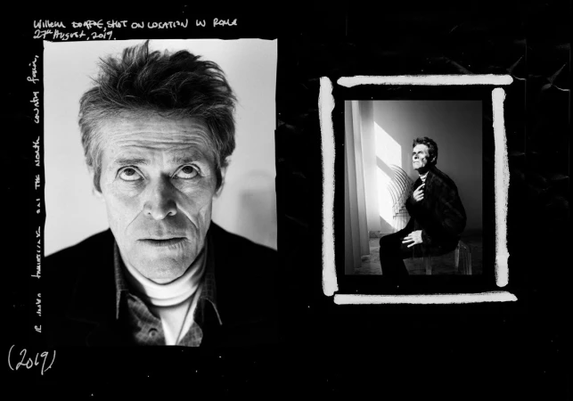 Black and white portrait of Willem Dafoe on location in Rome. The actor looks intently at the camera in a medium studio shot.