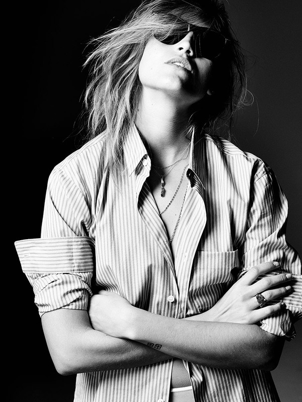 Black and white portrait of a woman in a striped shirt and sunglasses with arms crossed