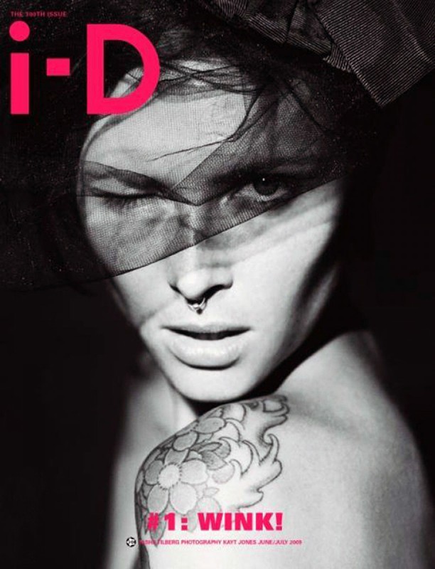 Black and white magazine cover shot featuring a winking adult female with a floral tattoo and black veil. I-D magazine logo in pink.