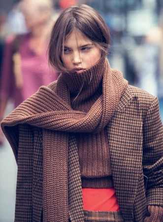 Portrait of a woman wearing a brown houndstooth blazer and a chunky knit turtleneck scarf by David Bellemere