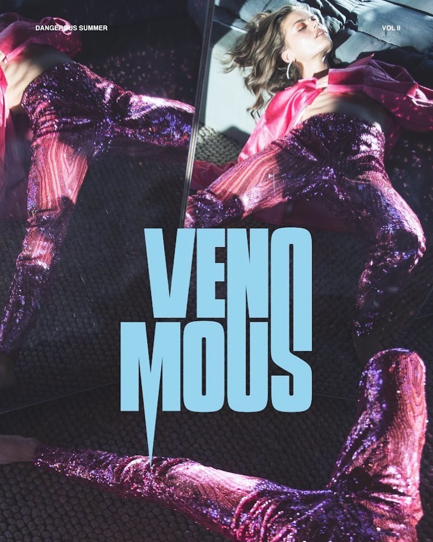 Woman in sparkling pants and a pink jacket, resting in front of a mirror, with the words VENOMOUS SUMMER VOL II in the foreground.