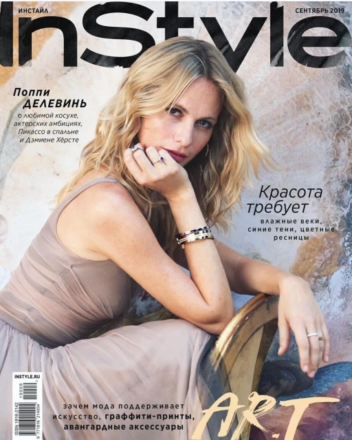 InStyle magazine cover featuring Poppy Delevingne in a beige dress, accessorized with bracelets and rings, sitting against an artistic backdrop.