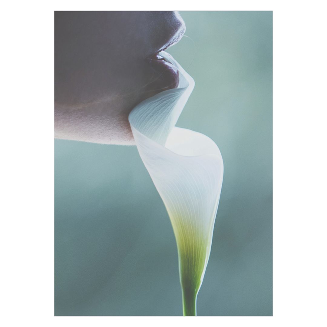 Close-up of a woman's mouth in partial view, holding a white calla lily flower. Soft lighting and a muted color palette evoke elegance.