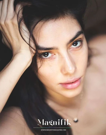 Close up portrait of a woman with dark hair touching her head by David Bellemere