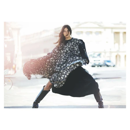 Model in floral print dress and black boots posing on city street by David Bellemere