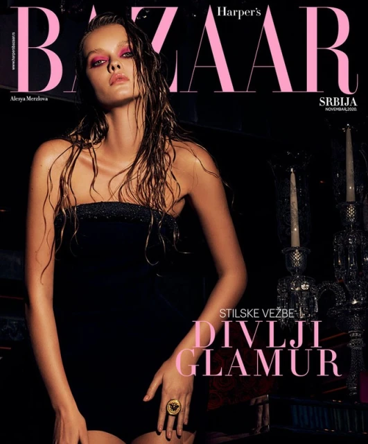 Harper's Bazaar cover featuring a wet-haired fashion model in a black strapless bodysuit and large gold ring, dark moody background.