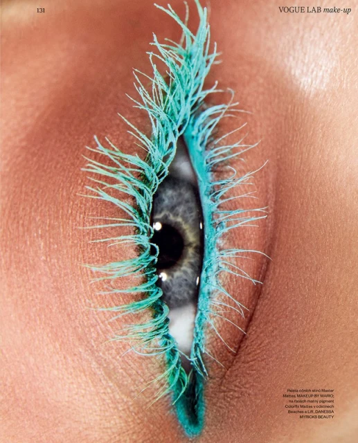 Close-up of a single eye with blue mascara on the eyelashes and lower lash line in a beauty and fashion style macro photograph.