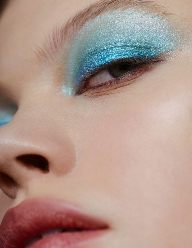 Close-up portrait of a woman wearing metallic blue eyeshadow and natural lipstick by make-up artist David Razzano