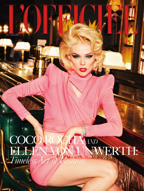 Blonde model Coco Rocha wears a pink dress and sits in a green chair for L'Officiel magazine cover, with dark bar background.