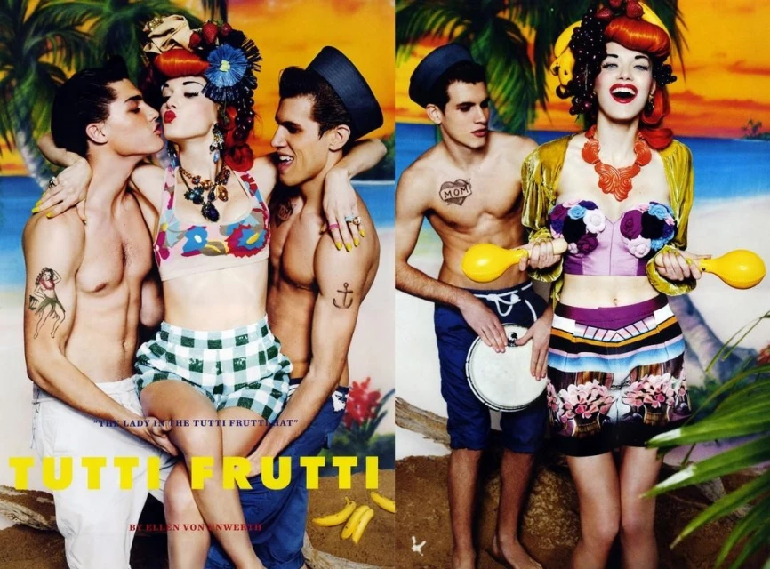 Vibrant fashion editorial featuring two men and one woman in summer outfits posing in front of a painted beach backdrop with tropical fruit.