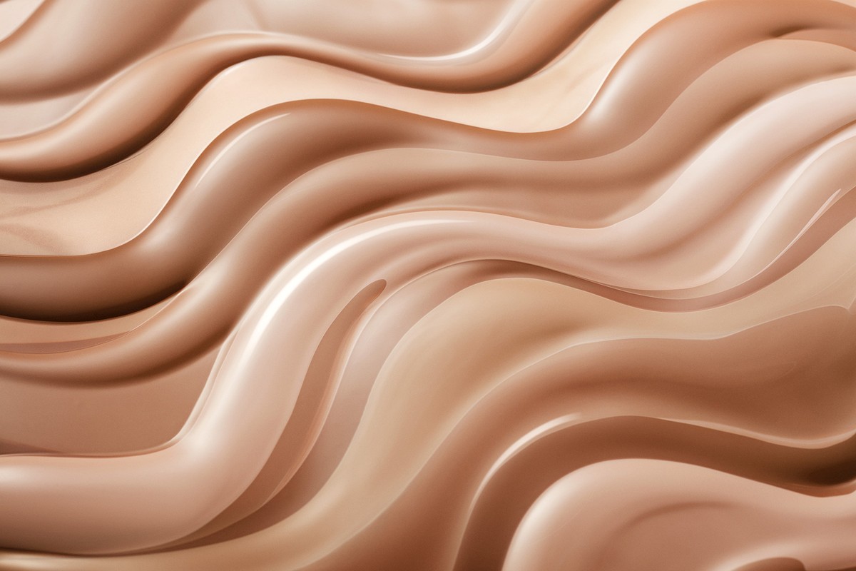 Abstract flowing background image with shades of beige and brown creating smooth, wavy textures and patterns.