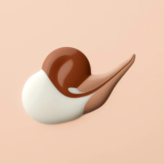 Swirls of brown, tan, and white cosmetic foundation or cream against a light pink background in a beauty product shot.
