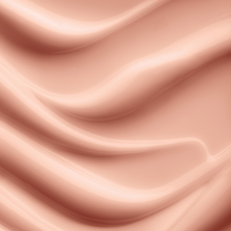 Macro abstract close-up of a textured, rippled, wavy surface with soft, muted peach and coral colors and subtle lighting.