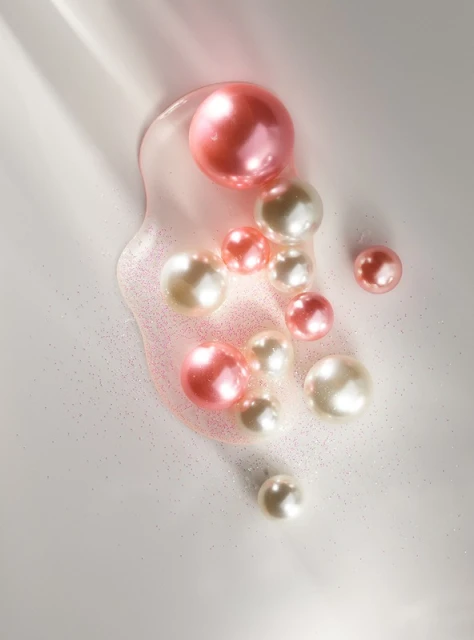 Close-up of a collection of pearl-colored and pink spheres and droplets of liquid, creating a visually appealing abstract composition.