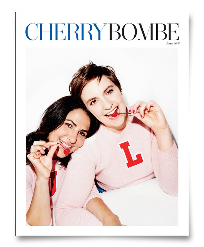 Magazine cover featuring two smiling women in pink sweaters, each holding a cherry, against a bright white background.